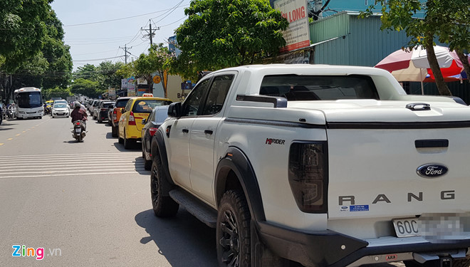 H&agrave;ng chục &ocirc;t&ocirc; xếp h&agrave;ng d&agrave;i đối diện ph&ograve;ng c&ocirc;ng chứng ở thị trấn Dương Đ&ocirc;ng. Những người đi mua đất đa số đến từ H&agrave; Nội, B&igrave;nh Dương, TP.HCM... Ảnh: Việt Tường.